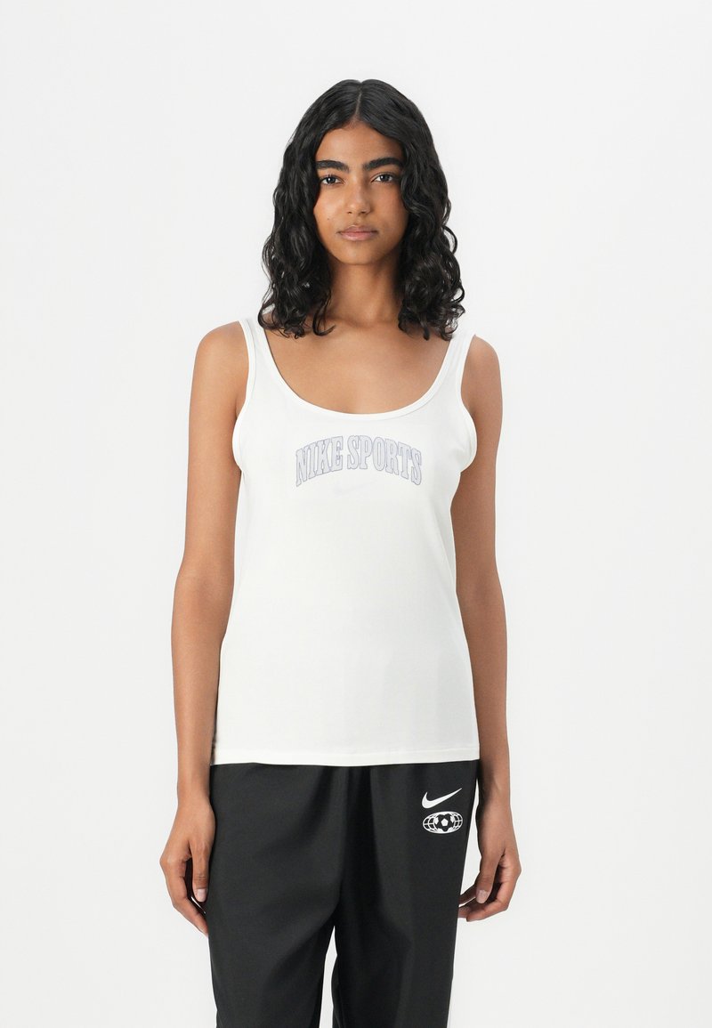 Hvit tank topp med rund hals og tynne stropper, med en "NIKE SPORTS" grafikk i lilla over brystet. Glatt tekstur.
