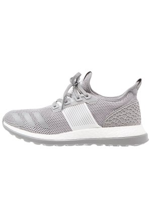 Chaussure de sport gris clair avec tige en mesh, fermeture à lacets, talon texturé et semelle blanche coussinée avec semelle extérieure grise.
