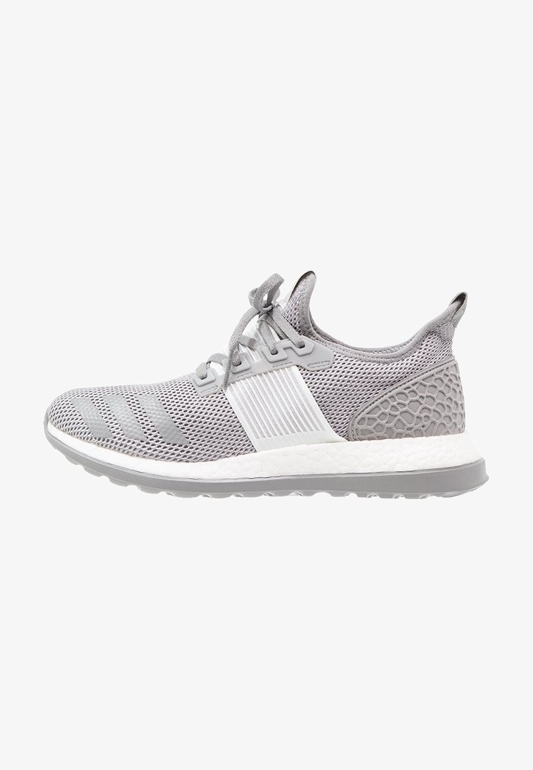 Chaussure de sport gris clair avec tige en mesh, fermeture à lacets, talon texturé et semelle blanche coussinée avec semelle extérieure grise.