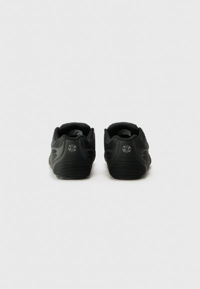 Baskets de sport noires avec un dessus en mesh texturé, semelle en caoutchouc et section de talon striée. La vue arrière montre un détail du logo et un design arrondi.