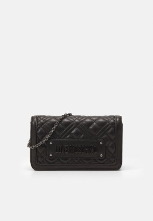 Bolso bandolera de cuero negro acolchado con correa de cadena metálica y placa con relieve "LOVE MOSCHINO" en la solapa frontal.