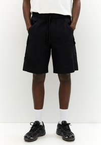Sorte cargo shorts med elastisk talje, frontlommer og sidelommer. Lavet af et let stof med en afslappet, løs pasform.
