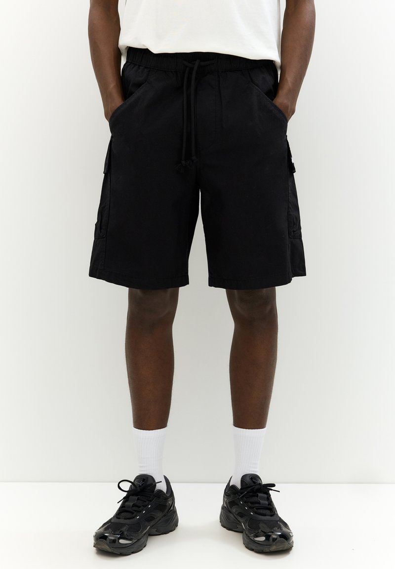Sorte cargo shorts med elastisk talje, frontlommer og sidelommer. Lavet af et let stof med en afslappet, løs pasform.