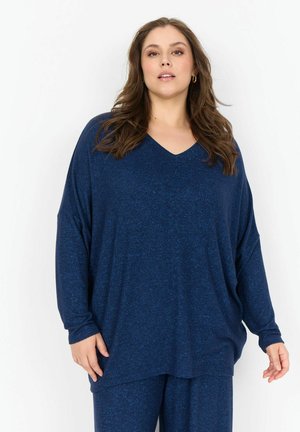 Camiseta de color azul marino, de corte holgado, con escote en V, mangas largas y una tela suave y texturizada. Diseñada para la comodidad con una silueta relajada.