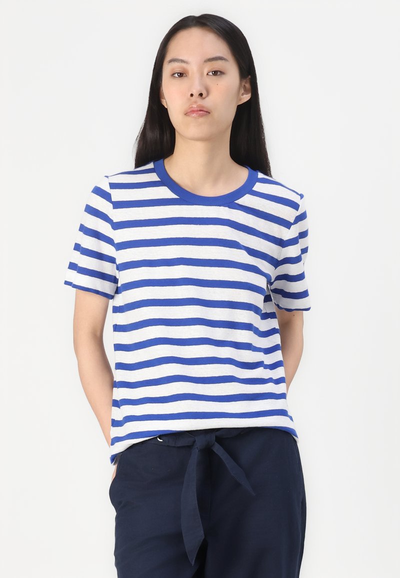 Blau-weiß gestreiftes T-Shirt mit rundem Ausschnitt und kurzen Ärmeln, aus weichem Stoff hergestellt. Kombiniert mit navyblauen Hosen mit gebundenem Bund.