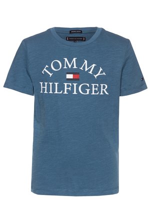 Niebieska koszulka bawełniana z krótkim rękawem z napisem i logo "TOMMY HILFIGER" w białym i czerwonym, umieszczonym na środku z przodu.
