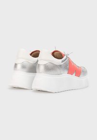 Metalické stříbrné tenisky s korálovým akcentem, texturovaným svrškem a zvýšenou bílou podrážkou s vroubkovaným vzorem. Šňůrky jsou bílé.