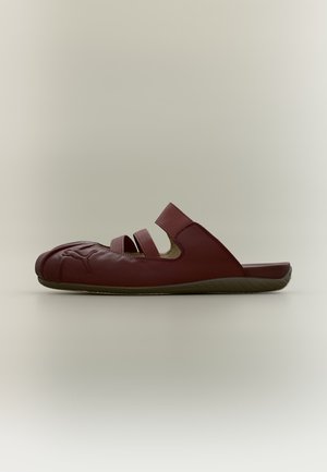 Σκούρο κόκκινο σανδάλι slip-on με τρεις λουρίδες και σκαλιστό σχέδιο στα δάχτυλα, εμφανίζεται σε πλευρικό προφίλ σε ουδέτερο φόντο.