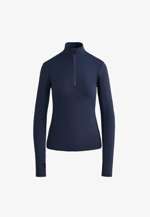 Chemise à manches longues bleu marine avec col demi-fermeture éclair, texture côtelée et trous pour les pouces aux poignets pour un maintien sécurisé. Fabriquée en matériau extensible.