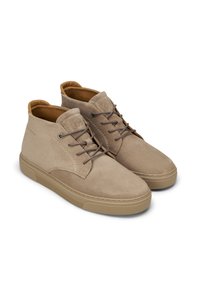 Beige Wildleder-Stiefeletten mit glatter Textur, runder Spitze und braunem Lederfutter. Mit braunen Schnürsenkeln und Gummisohle.