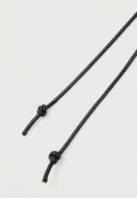 Must nöör kahe sõlmitud otsaga, millel on sile tekstuur ja õhuke punutud disain. Materjal näib vastupidav ja paindlik.