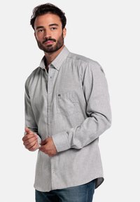 Grijze overhemd met knopen, een zak, lange mouwen, zachte textuur en een casual pasvorm, gecombineerd met blauwe jeans. Knopen en logodetails zichtbaar.