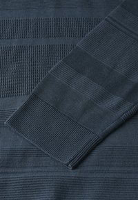 Dark blue sweater featuring textured stripes and ribbed cuffs. Material appears soft with varying patterns across the fabric surface.