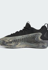 Scarpa sportiva nera con una tomaia texturizzata, distinti pannelli laterali in rete e una suola traslucida marmorizzata con un design curvo unico.