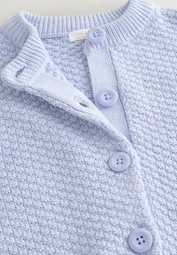 Cardigan en maille bleu clair avec un motif texturé et quatre boutons ronds assortis sur le devant.