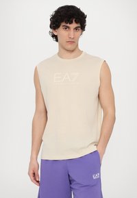 Smėlinė be rankovių marškinėliai su apvalia iškirpte, ant krūtinės su iškilniu EA7 Emporio Armani logotipu. Lygi medžiaga; vientisa dizaino forma.