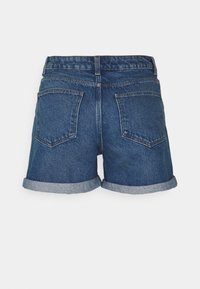 Pantalones cortos de mezclilla con un lavado azul clásico, que presentan dobladillos enrollados y dos bolsillos traseros, cosidos con detalle de hilo en contraste.