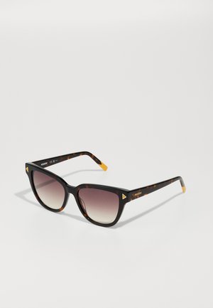 Tortoiseshell sunglasses with a wide, angular frame, gradient lenses, and yellow accents on the temples, featuring triangular details.