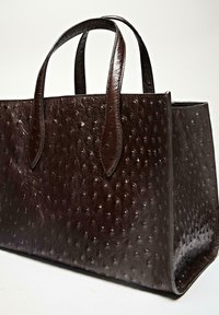 Braune Ledertasche mit geprägter Textur, glatten Griffen und einer strukturierten rechteckigen Form. Keine sichtbaren Metallteile enthalten.