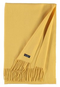 Écharpe jaune en tissu doux, avec une surface texturée, des franges aux extrémités et une petite étiquette de marque attachée.