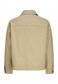 Veste beige à manches longues avec un col droit, des poignets boutonnés et une couture traversant le haut du dos.