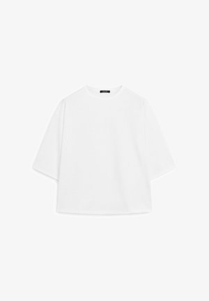 T-shirt bianco oversize realizzata in morbido cotone. Caratterizzata da maniche corte, un colletto tondo e una vestibilità rilassata senza modelli o dettagli visibili.