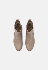 Bottes de cheville en daim marron avec des panneaux élastiques sur les côtés, bout rond et tirant à l'arrière. Intérieur doublé pour un confort accru.