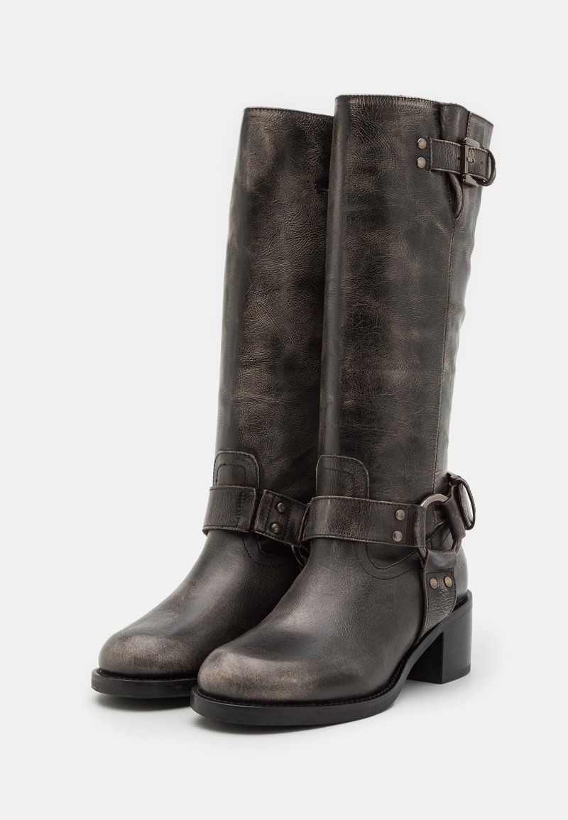 Stivali neri in pelle al ginocchio con una texture leggermente invecchiata, caratterizzati da una fibbia laterale e dettagli metallici, e un tacco basso a blocco.