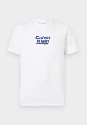 T-shirt blanc à manches courtes avec le logo bleu "Calvin Klein Est. 1968" imprimé au centre de la poitrine.
