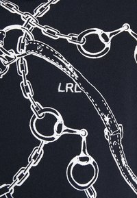 Svart tyg med vit kedja och handtag grafiskt tryck. Innehåller cirkulära ringar och intrikata kedjelänkar. Subtilt varumärkeslogotyp, "LRL," synlig.