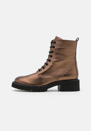 Metallisch bruine enkelboot met een ronde neus, vetersluiting aan de voorkant, gestructureerd oppervlak en een stevige zwarte rubberen zool. Voorzien van een trekband aan de achterkant.