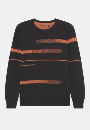 Pull noir à manches longues avec des rayures horizontales orange et le texte "GUESS LOS ANGELES 1981" inscrit sur le devant et les manches.