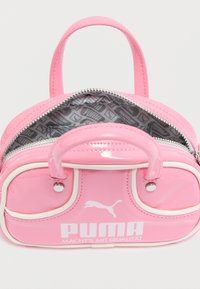 Ροζ τσάντα χειρός από δερματίνη με λευκές λεπτομέρειες, στρογγυλεμένο σχήμα, διπλές λαβές και κλείσιμο με φερμουάρ. Το εσωτερικό διαθέτει επένδυση με μοτίβο.