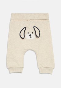 Μπεζ βαμβακερό παντελόνι με σχέδιο πρόσωπο σκύλου, με μαύρα περιγράμματα στα αυτιά και τα μάτια, και ριμπ μανσέτες για ασφαλή εφαρμογή.