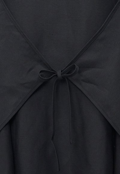 Μαύρο ρούχο από ύφασμα με λαιμόκοψη σε σχήμα V, δεμένο στη μέση με λεπτό φιόγκο.
