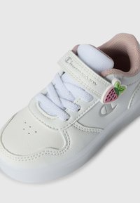 Sneaker bianco in pelle con finitura texturizzata, presenta un rivestimento in mesh rosa, lacci bianchi e un accento a forma di fragola sulla fascetta.