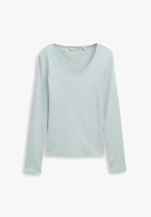 Hosszú ujjú felső világoskék színben, bordázott anyagból készült. Széles kerek nyakkivágással és testhezálló fazonnal rendelkezik, egyenes szegéllyel.