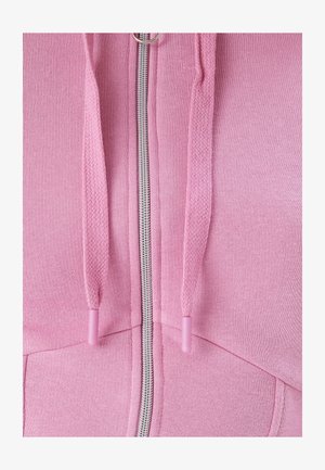 Felpa con zip rosa che presenta una cerniera argentata, un cordino testurizzato con punte coordinate e una finitura in tessuto morbido.