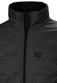 Chaqueta aislante negra con un cuello alto, que presenta un cierre de cremallera y un sutil patrón geométrico. Logo de la marca en la esquina superior izquierda.