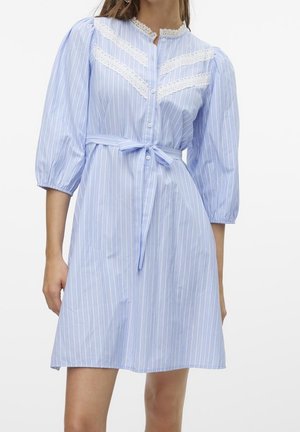 Jasnoniebieska sukienka z białymi pionowymi paskami, koronkowymi detalami na dekolcie i kołnierzu, bufkami o długości do połowy przedramienia oraz paskiem wiązanym w talii.