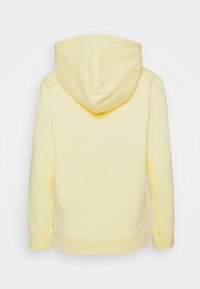 Sudadera amarilla hecha de una tela suave, con un bolsillo tipo canguro, puños y dobladillo acanalados, y una capucha de doble capa.