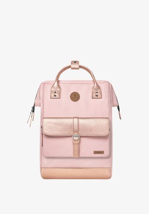 Pink backpack with metallic rose gold accents, textured flap, sturdy handles, zippered closure, and a logo patch on the front.