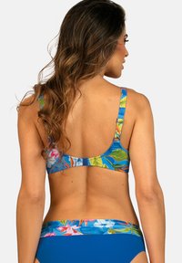 Góra bikini z nadrukiem kwiatowym w niebieskich paskach, kolorowymi wzorami liści oraz zapięciem na zatrzask. Dopasowane niebieskie majtki o gładkiej fakturze.