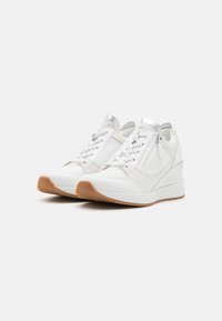 Weiße Sneakers mit einem strukturierten Design und Akzenten aus Mesh und Leder. Runde Zehen, flache Sohle und ein leichter Keilabsatz. Detail in Silber.