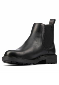 Botín Chelsea de cuero negro con panel lateral elástico, tirador en la parte trasera, suela gruesa y tacón bajo apilado.