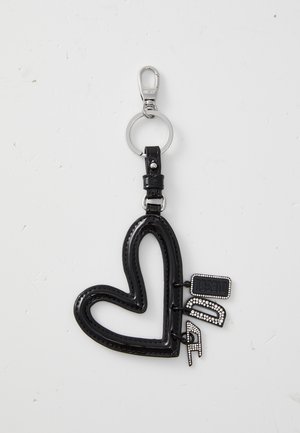 Black heart-shaped keychain made of shiny material with decorative stitching, attached to a metal keyring, featuring branded tags.