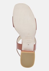 Sandal in pelle marrone con suola piatta e liscia e tacco a blocco. Presenta due cinghie incrociate e testo del marchio impressa sulla soletta. Taglia 38.