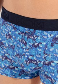 Boxers pour hommes avec une ceinture bleu marine et un motif paisley bleu. Caractérisés par une texture de tissu douce et un design ajusté.