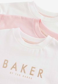 Tri majice imaju dizajn s okruglim izrezom u bijeloj i svijetloljubičastoj boji. Na prednjem dijelu je zlatni logotip "BAKER". Mekana pamučna tekstura.