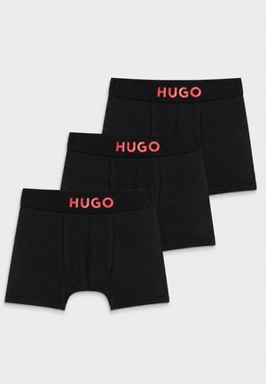 Drei schwarze Boxershorts mit rotem HUGO-Logo auf dem Bund, übereinander auf einem weißen Hintergrund angeordnet.